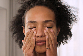 woman touching the area around her eyes